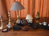 a table with a lamp, a clock, a clock and other items on it