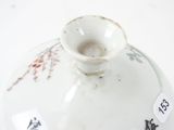 a white vase with a floral design on it