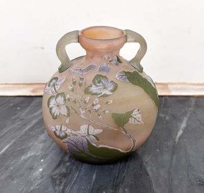 un vase posé par terre, dans lequel se trouvent des fleurs