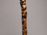 a wooden sculpture of a man with a bird on his head