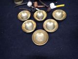 a lot of brass bells on a black table