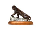 figurine of a tiger on a rock on a white background