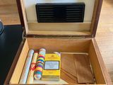 a wooden box with a clock and a cigarette in it