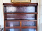 a large wooden bookcase in a room with a painting on the wall