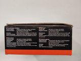 an orange box with a black label on it sitting on a white surface