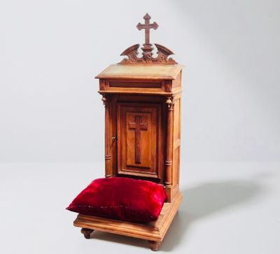 a small wooden chair with a red pillow on it