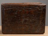 an old wooden box sitting on top of a table next to a gray wall