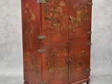 une vieille armoire en bois ornée d'un tableau sur la façade