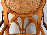 a wooden rocking chair with a wicker seat on it