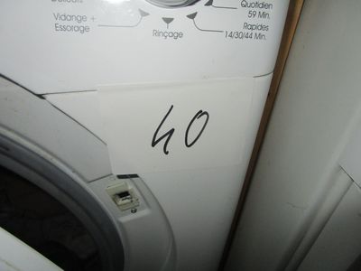 une machine à laver blanche posée à côté d'un sèche-linge dans une pièce