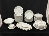 beaucoup d'assiettes et de bols blancs sur une table