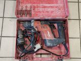 une boîte à outils rouge contenant des outils, posée sur un sol carrelé