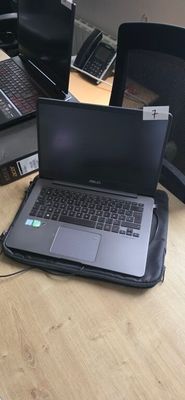 three laptops sitting on a desk in a room