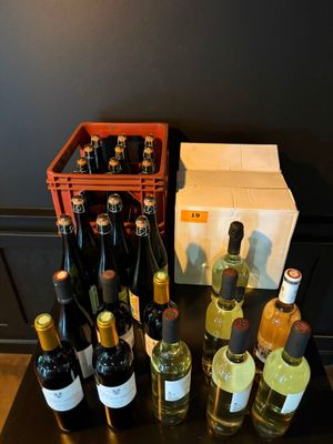 plusieurs bouteilles de vin posées sur une table à côté d'une boîte de vin