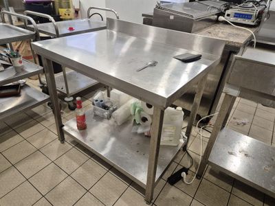 une table de travail en acier inoxydable sur laquelle se trouve un téléphone