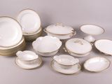 an assortment of white and gold china dishes and plates