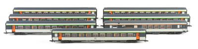 three model trains sitting side by side on a white surface