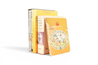 plusieurs livres sont empilés sur une surface blanche