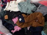 a pile of clothes in a basket on a bed