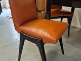 a brown leather chair sitting in front of a wooden table