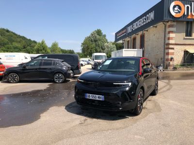 a black car parked in front of a building in a parking lot