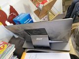 a laptop computer sitting on top of a desk next to a pile of books