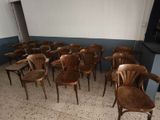 de nombreuses chaises en bois dans une pièce aux murs bleus