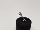 a close up of a diamond ring sitting on top of a black ring holder