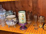 a shelf that has many different glassware on it