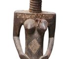 statue d'une femme coiffée d'une coiffe, les mains dans les poches