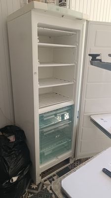 un réfrigérateur blanc dont la porte est ouverte, à côté d'une table