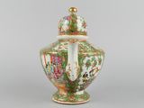 a close up of a vase with a lid on a gray surface