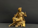 bronze statue of a woman sitting on a stool with a man sitting on her lap