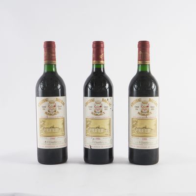 trois bouteilles de vin sont alignées sur une surface blanche