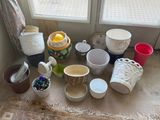 de nombreuses tasses et bols posés par terre près d'une fenêtre