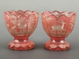pair of pink glass vases with deer and pine trees on them