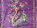 an image of a purple quilt with a peacock and flowers on it