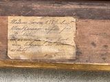 an old piece of paper on a piece of wood with writing on it