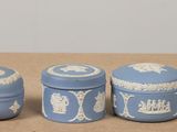 three small blue and white containers sitting on a table