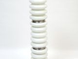 a white table lamp that is on a white surface