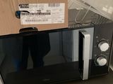 un micro-ondes sur lequel est posé un carton