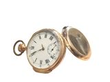 a gold pocket watch with roman numerals on it