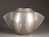 a silver vase that is sitting on a table