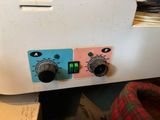 two controls on the side of a white machine