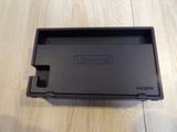 a black nintendo game console sitting on a wooden floor