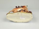 a close up of a figurine of a dog laying on top of a shoe