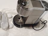 a coffee maker sitting on a table with a bag next to it