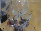 bottles and glasses on a table with a pitcher and a glass