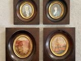 four framed portraits of people in a wood frame on a wall