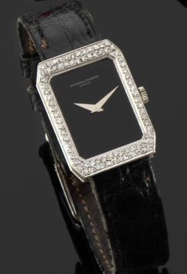 gros plan d'une montre sur une surface noire avec un fond noir